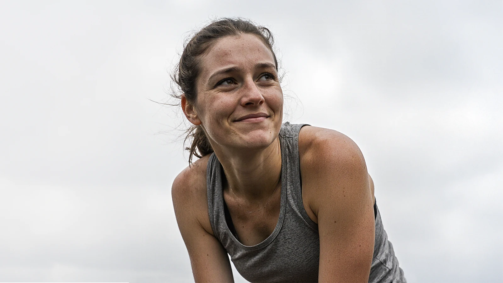 Female runner recovering after a run with her hands on her knees